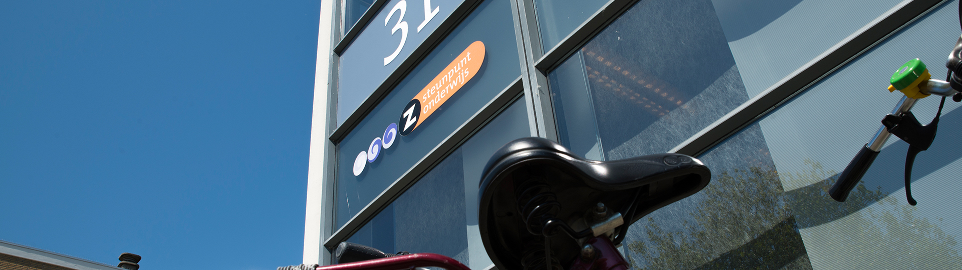 Gebouw met belettering van Steunpunt onderwijs en een fietszadel