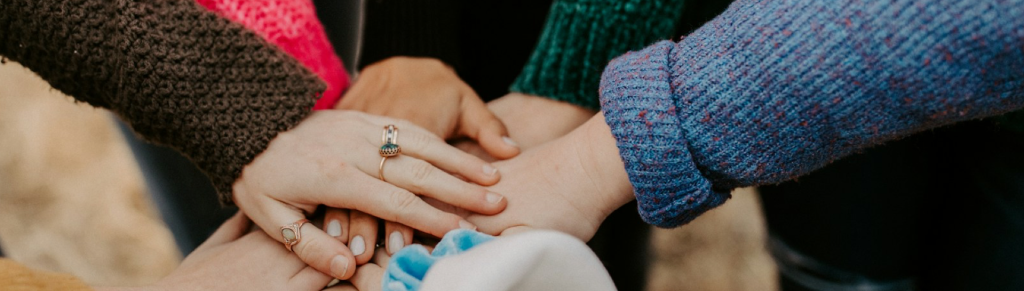 Meerdere leerlingen leggen de handen op elkaar